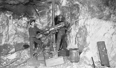 Two miners operating a pneumatic rock drill on the 1700-foot level in the Anaconda Mine