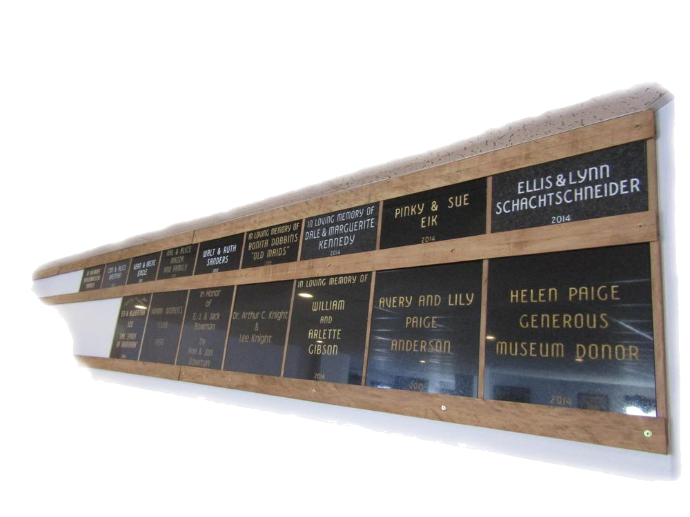 Wooden wall display featuring black stone memorial plaques engraved with donor names
