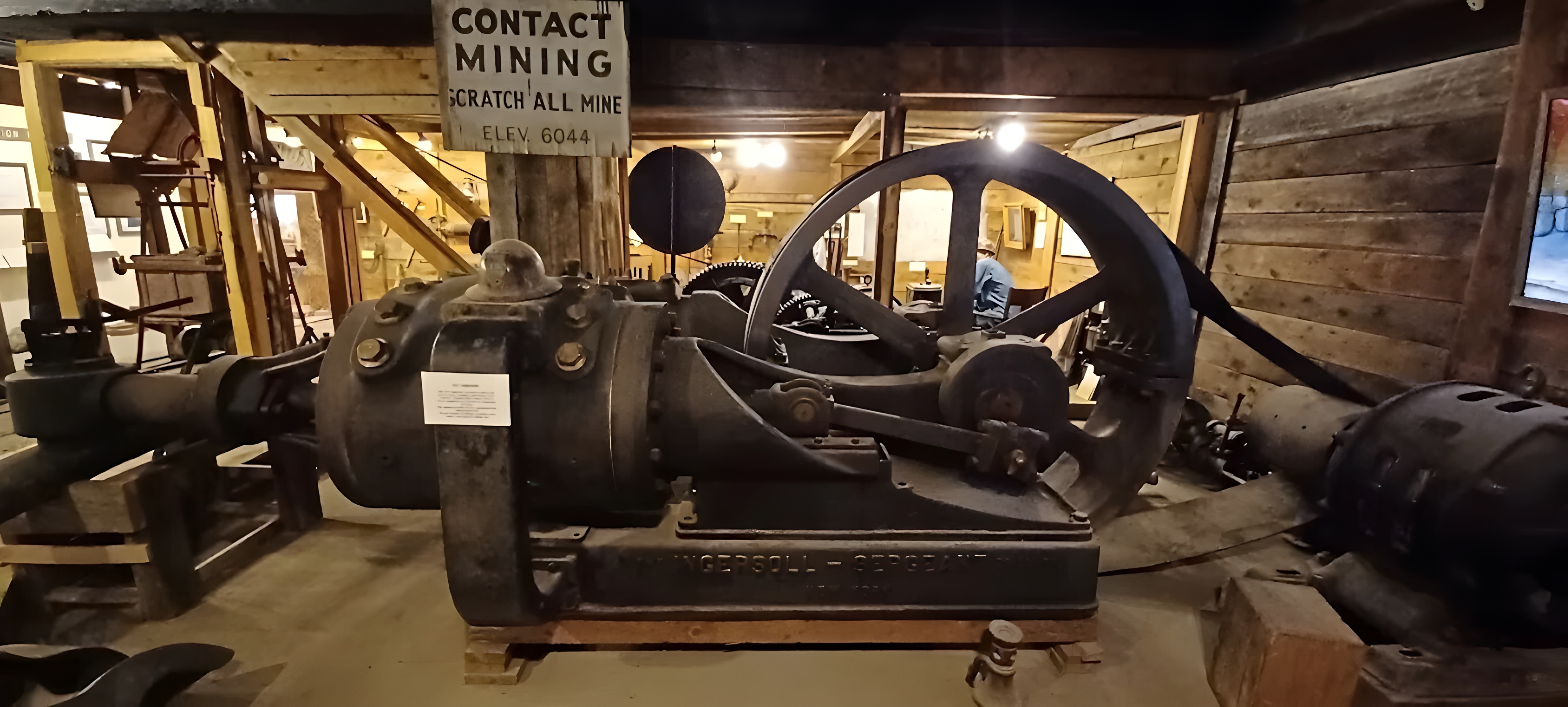 Weathered industrial hoist mechanism inside an old wooden mine structure