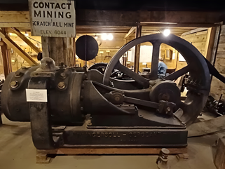 Weathered industrial hoist mechanism inside an old wooden mine structure